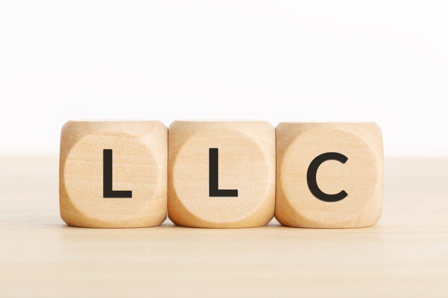 LLC or Limited Liability Company concept. Tex on wooden blocks on table. Copy space